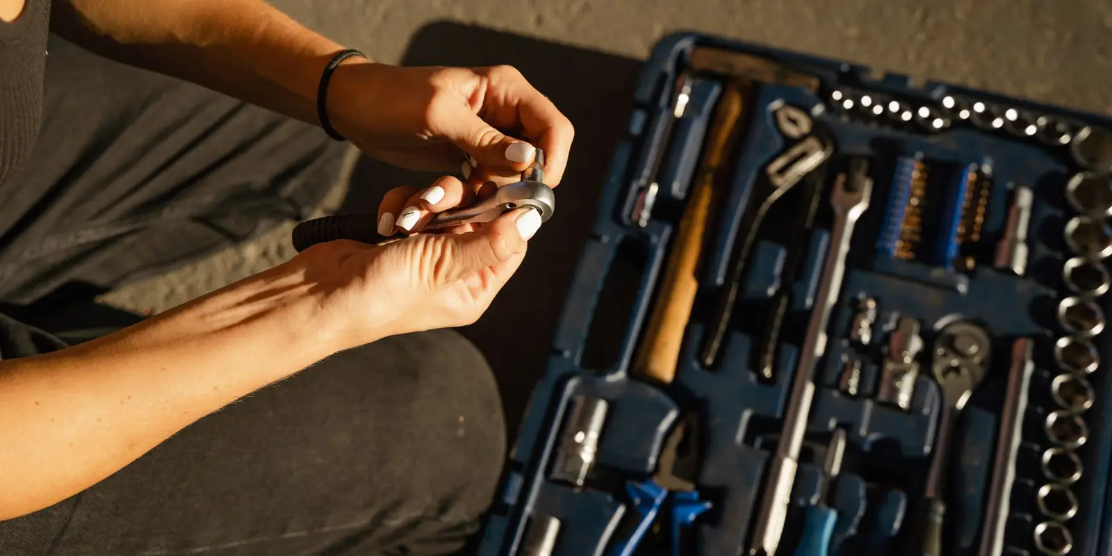 Plumber's tool kit with wrenches and pliers laid out on a work surface