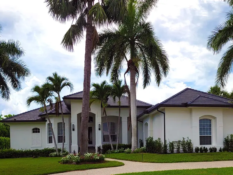 Plumber in Kendall: white house with palm trees and a dark tile roof