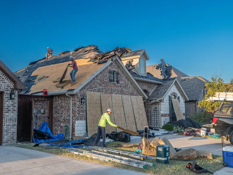 Roof replacement in Miami: crew re-roofing a house