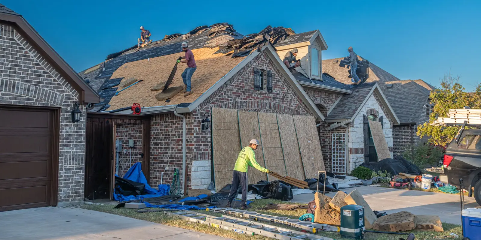 Roof replacement in Miami: crew re-roofing a house
