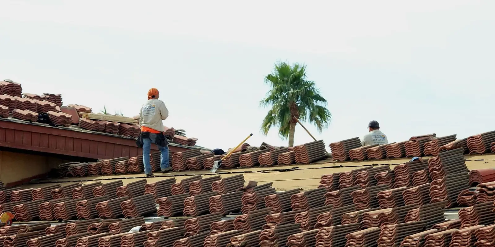 Roofing company in Miami working on a barrel tile roof
